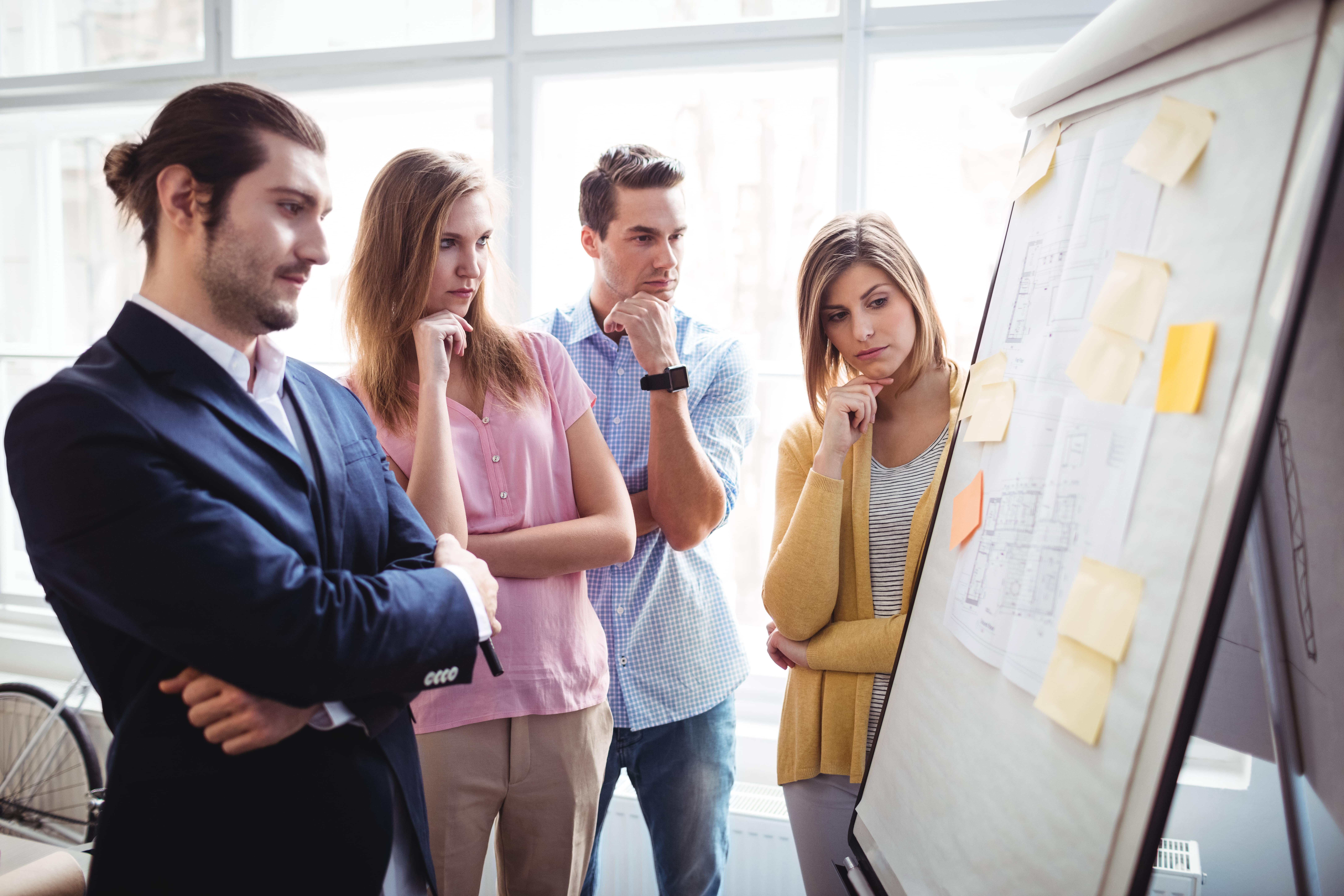 business-people-thinking-while-looking-at-blueprin-UBTZMW2-min